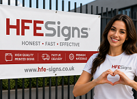 Woman making heart shape with hands beside HFE Signs printed advertising banner with fast UK delivery branding