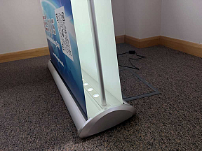 Double-sided LED illuminated banner stand with bright graphics for exhibitions, events and retail displays
